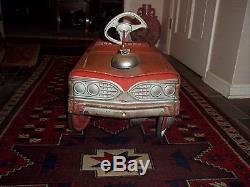 Vintage a red fire chief pedal car their is M initial on the wheel